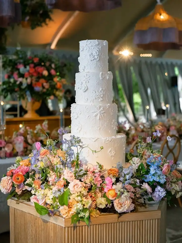 Where sugar blooms and love flourishes. 🤍🌸For Konnor & Josh, we created a timeless four-tier wedding cake adorned with d...