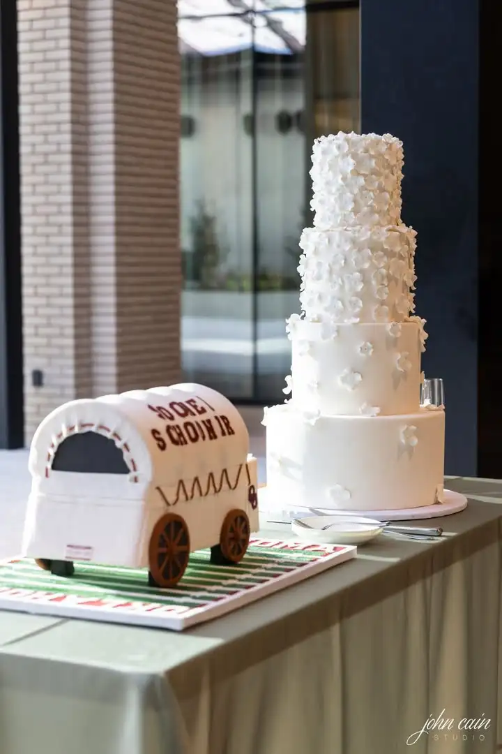 This elegant four-tier wedding cake featured hundreds of handcrafted white blossoms cascading from tier to tier, creatin...